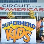 A sign that says superhero kids in front of the circuit of the americas.