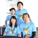 A family of four wearing matching blue shirts.