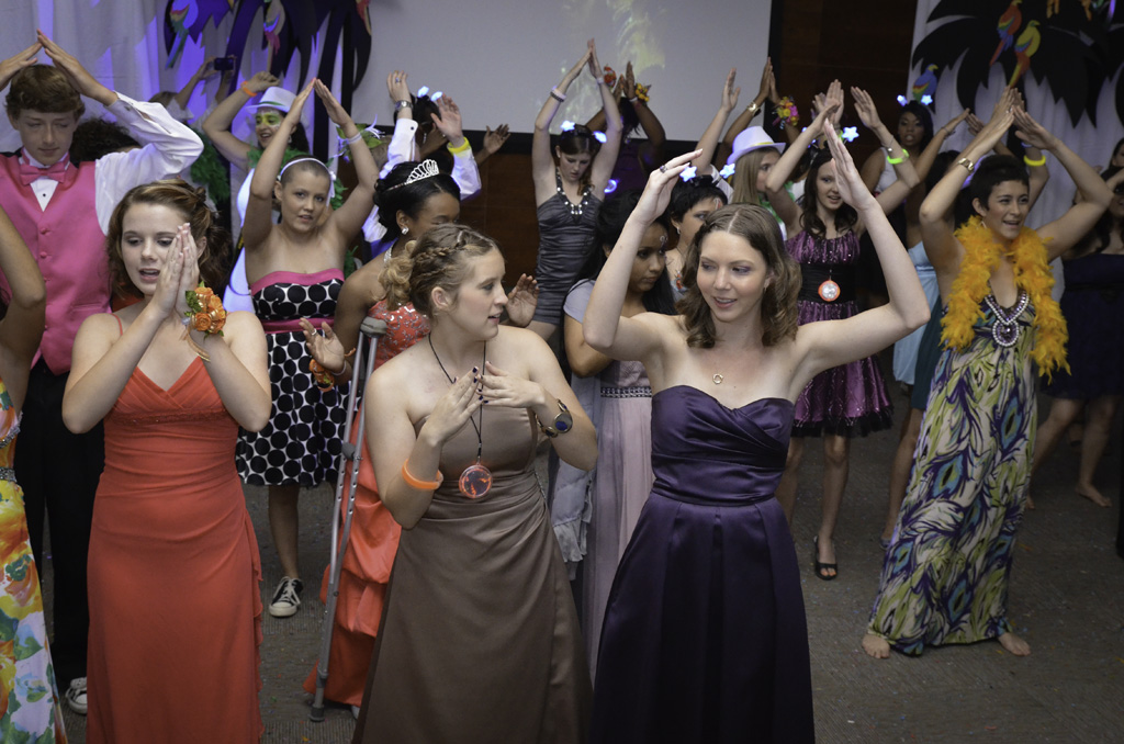 A group of people in dresses and hats dancing.