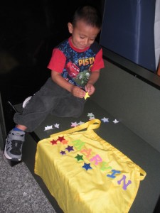 A young boy sitting on the floor next to a table.