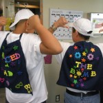 Two young men wearing backpacks with the words " iced bomb " on them.