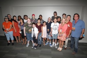 A group of people standing in front of a wall.