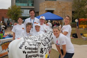 A group of people standing around a white elephant.