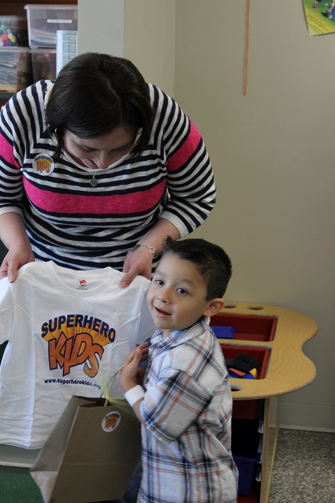A woman and boy holding up a t-shirt.