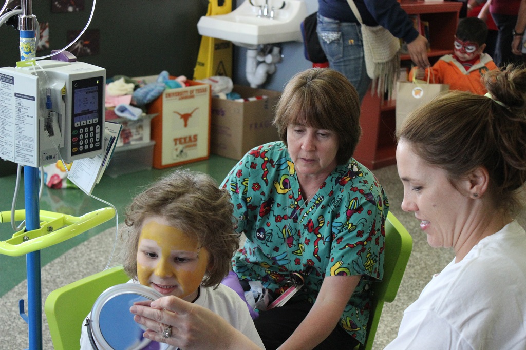 A woman and two women sitting in chairs with a child.