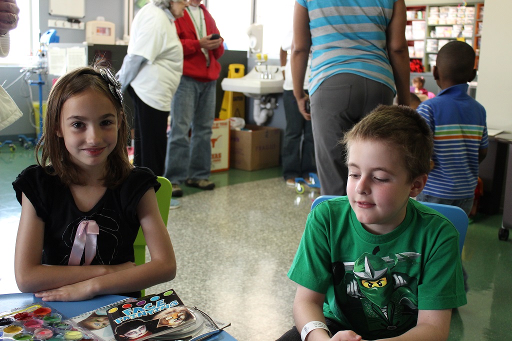 Two children sitting on the floor in a room.