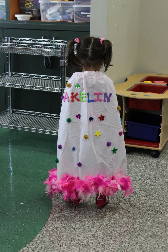 A little girl in a dress that says " makeliv ".
