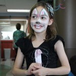 A girl with bunny ears and face paint.