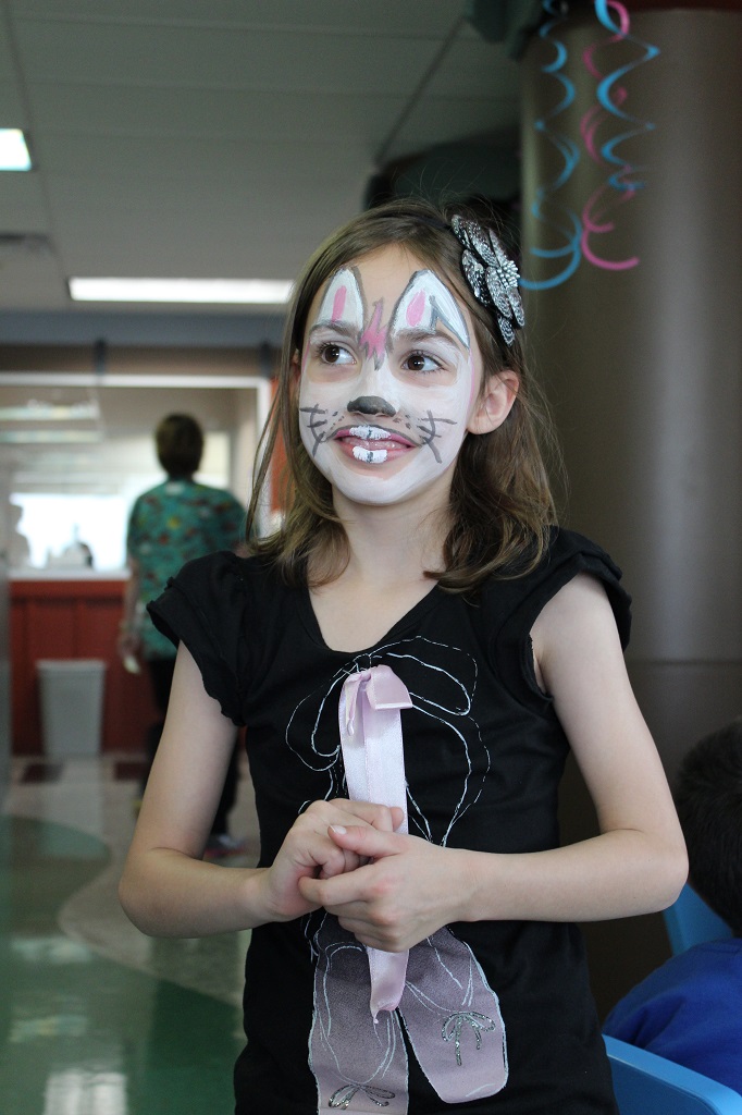A girl with bunny ears and face paint.
