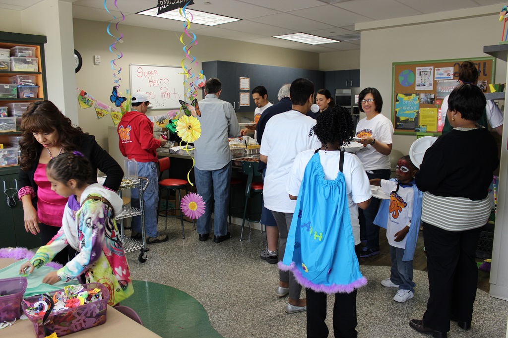 A group of people standing around in an office.