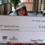 A girl holding up a giant check for $ 4, 0 0 0.